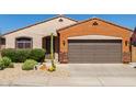 Attractive single-story home with stone accents, desert landscaping, and a two-car garage at 47719 N Camino Del Sol --, Gold Canyon, AZ 85118