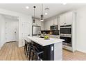 Kitchen with white cabinets, black countertops, stainless appliances and an island with barstool seating at 6641 N Desert Shadow Ln, Phoenix, AZ 85014