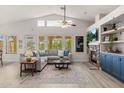 Bright living room with vaulted ceilings, stone fireplace, comfortable seating, and natural light at 7701 E Portobello Ave, Mesa, AZ 85212
