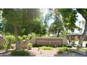 Scottsdale Shadows condominium community sign surrounded by lush trees and greenery at 7960 E Camelback Rd # 109, Scottsdale, AZ 85251
