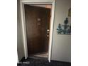 View of front door entryway, leading into a hallway with a mirrored closet and wood-look tile flooring at 7960 E Camelback Rd # 109, Scottsdale, AZ 85251