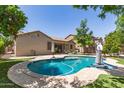 Inviting backyard features a sparkling pool, manicured lawn and covered patio perfect for outdoor living at 850 W Folley St, Chandler, AZ 85225