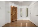 Bright entryway featuring a carved wood front door and hardwood floors at 9622 N 112Th Ave, Sun City, AZ 85351
