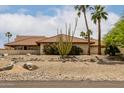 Tan house with desert landscaping, red tile roof and palm trees at 9622 N 112Th Ave, Sun City, AZ 85351