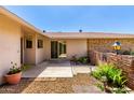 Private patio with a lovely brick border, rock landscaping, and access to the house at 9805 W Gulf Hills Dr, Sun City, AZ 85351