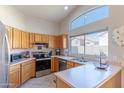 Bright kitchen featuring stainless steel appliances, light countertops, and natural wood cabinetry at 17434 N 46Th Pl, Phoenix, AZ 85032