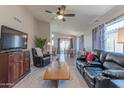 Comfortable living room showcasing a black leather sofa, ceiling fan, and view into dining room at 17434 N 46Th Pl, Phoenix, AZ 85032
