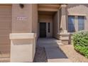 Cozy front entrance with a black screen door, house number, and easy access to the garage at 10228 E Carol Ave, Mesa, AZ 85208