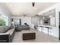 Inviting living area featuring sleek gray sofas, stylish flooring, and seamless access to the kitchen at 1042 E Utopia Rd, Phoenix, AZ 85024