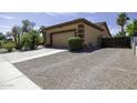Spacious two-car garage with a gravel driveway and a side gate, providing ample parking and storage at 1123 E Shepherds Way, Casa Grande, AZ 85122
