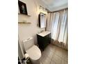 Charming bathroom with a vintage vanity, decorative mirror, and elegant shower curtain at 1222 E Almeria Rd, Phoenix, AZ 85006