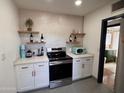 Well-equipped kitchen boasts stainless steel stove, white cabinets and floating shelves at 1222 E Almeria Rd, Phoenix, AZ 85006