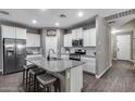 Modern kitchen boasts granite countertops, a center island with seating, and stainless steel appliances at 13657 W Paso Trl, Peoria, AZ 85383