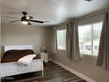 Bright bedroom with two large windows, a ceiling fan, neutral walls, and luxury vinyl plank flooring at 17344 W Adams St, Goodyear, AZ 85338