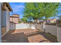 Spacious backyard with brick-paved patio and white privacy wall perfect for entertaining at 1768 E Grand Ridge Rd, Queen Creek, AZ 85140