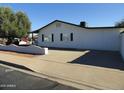 This cozy home features a long driveway, rear windows with black shutters, and a privacy wall at 1922 N 21St Pl, Phoenix, AZ 85006