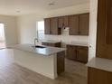 Open kitchen featuring an island with a sink, wood cabinets, and stainless steel appliances at 20346 W Sells Dr, Buckeye, AZ 85396