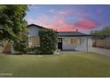 Charming home with green lawn, mature landscaping, and freshly painted white exterior at 2336 E Flower St, Phoenix, AZ 85016