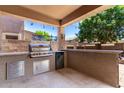Covered outdoor kitchen includes a built-in grill, counter space, and bar seating at 283 W Tahiti Dr, Casa Grande, AZ 85122