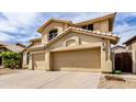 View of the home with an attached three-car garage, large driveway, and desert landscaping at 3132 E Wildwood Dr, Phoenix, AZ 85048