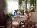 Cozy dining area bathed in sunlight, complemented by lush greenery and a round lace-covered table for intimate meals at 4083 E Rustler Way, Gilbert, AZ 85297