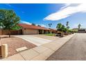 Spacious driveway leading to a two-car garage, with desert landscaping and a well-kept lawn at 410 E Beck Ln, Phoenix, AZ 85022