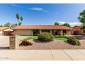 Well-maintained front yard with mature landscaping, a decorative brick pillar, and a lush green lawn at 410 E Beck Ln, Phoenix, AZ 85022