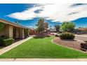 Lush green front yard with decorative rock landscaping and manicured bushes enhancing the home's curb appeal at 410 E Beck Ln, Phoenix, AZ 85022