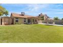 Spacious backyard with lush green grass, covered patio, shed and a fenced in pool area at 4213 W Calle Lejos --, Glendale, AZ 85310
