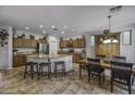 Spacious kitchen with island, wood cabinetry, and a casual dining area at 43330 W Delia Blvd, Maricopa, AZ 85138