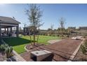 Expansive backyard with artificial grass, covered patio, outdoor kitchen, and shaded seating at 43712 N Acadia Way, New River, AZ 85087