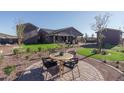 Inviting backyard featuring an outdoor seating area with lush green grass and manicured landscaping at 43712 N Acadia Way, New River, AZ 85087