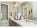 Bright bathroom with double sinks, marble countertop, decorative fixtures, and tiled shower at 43712 N Acadia Way, New River, AZ 85087