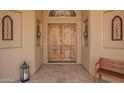Elegant double front door with sidelights, arched window, and stone tile floor at 4727 E Rancho Caliente Dr, Cave Creek, AZ 85331