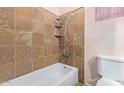 Cozy bathroom featuring a shower-tub combination with stylish tile surround and corner shelves at 501 E Hill Dr, Avondale, AZ 85323