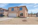 Front exterior featuring a two-car garage, low maintenance landscaping, and modern window design at 5401 N 104Th Dr, Glendale, AZ 85307
