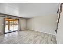 Open-concept living room with tile floors, leading to a glass sliding door and view of the backyard at 5401 N 104Th Dr, Glendale, AZ 85307