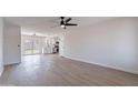 Spacious living room featuring wood floors, modern ceiling fan, and adjacent kitchen at 733 W El Prado Rd, Chandler, AZ 85225