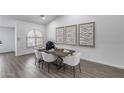 Charming dining room with a wood table, white chairs, decorative art and a window at 8449 W Rockwood Dr, Peoria, AZ 85382