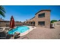 Large backyard with a refreshing pool, rock features, lounge chairs, and an outdoor patio area at 853 W Hemlock Way, Chandler, AZ 85248
