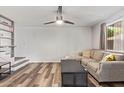 Inviting living room featuring a ceiling fan, stylish sofa, floating shelf staircase, and wood flooring at 8538 E Portland St, Scottsdale, AZ 85257