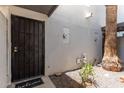 Covered entryway featuring a secure black metal door, desert landscape, and a 'Welcome' mat at 8552 E Indian School Rd # B, Scottsdale, AZ 85251