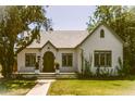 Charming single-story home featuring a white stucco exterior, green door, and lush landscaping at 917 W Willetta St, Phoenix, AZ 85007