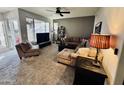 Spacious living room with comfortable seating, a ceiling fan, and a large window for natural light at 11680 E Sahuaro Dr # 2011, Scottsdale, AZ 85259