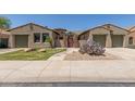 Charming home featuring desert landscaping, a gated entry, and dual two-car garages at 14538 W Sheridan St, Goodyear, AZ 85395