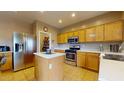 Well-equipped kitchen features stainless steel appliances, a center island, and ample cabinet space for storage at 16807 W Carmen Dr, Surprise, AZ 85388