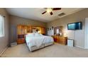 Comfortable main bedroom with a king bed, mirrored closet, ceiling fan, and a relaxing atmosphere at 16807 W Carmen Dr, Surprise, AZ 85388