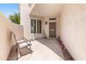 Private patio with chairs, outdoor lighting and security door in a neutral color palette at 1747 E Northern Ave # 104, Phoenix, AZ 85020