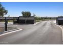 Gated community entrance with a secured brick wall, iron gates, and newly paved roads at 17567 W Pierson St, Goodyear, AZ 85395