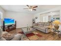 Bright living room features wood flooring, modern ceiling fan, and comfortable seating, creating an inviting atmosphere at 2061 E Flintlock Way, Chandler, AZ 85286